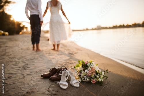 The bride's and the groom's feet in the sand on the beach