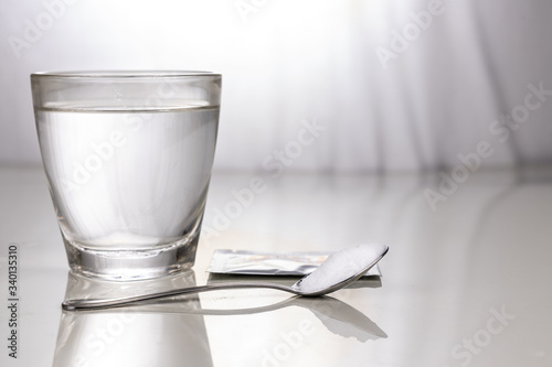 ORS or oral rehydration salt with glass of water, sachet and spoon photo