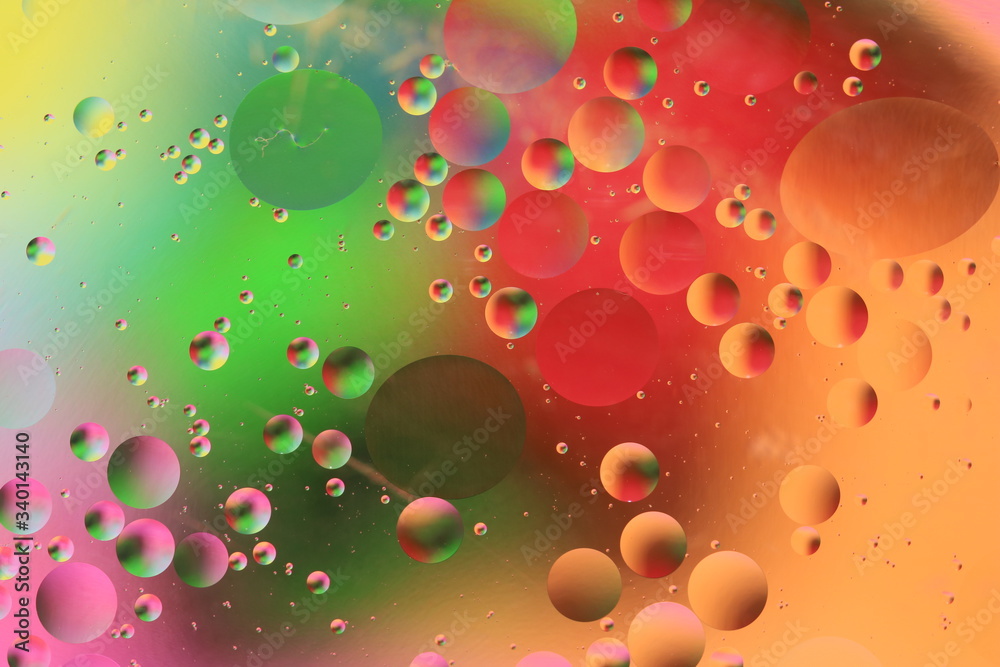 macro of oil mixed with water on colorful red, yellow, pink, green, blue and orange background, colourful circles, copy space, horizontal macro of oil mixed with water on colorful red, yellow, pink, green, blue and orange background, colourful circles, copy space, horizontal