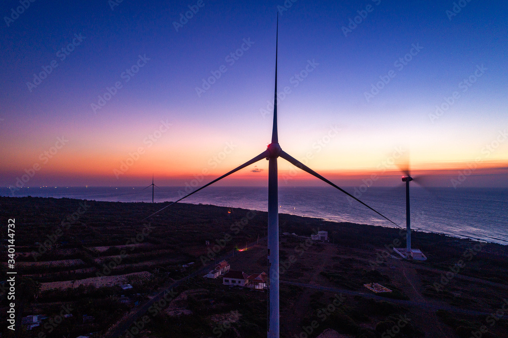 Fototapeta premium Aerial view of landscape with Turbine Green Energy Electricity, Windmill for electric power production, Wind turbines generating electricity on Phu Qui island, Binh Thuan, Vietnam. 