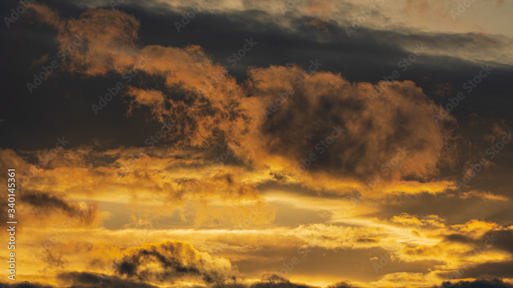 Dramatic clouds illuminated rising of sun in sky to change weather. Natural meteorology background. Blurred motion, soft focus. Majestic cloudscape image ready for design, replace sky in photo editor.