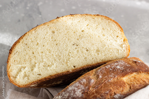 Artisan rustic bread from wheat flour on light grey stone background, selective focus. 