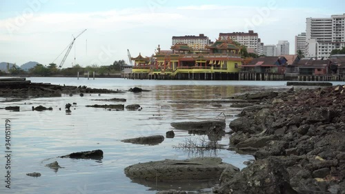 Abandoned tire and dirty at coastal near clan jetty. Background is Hean Boo Thean Temple. photo