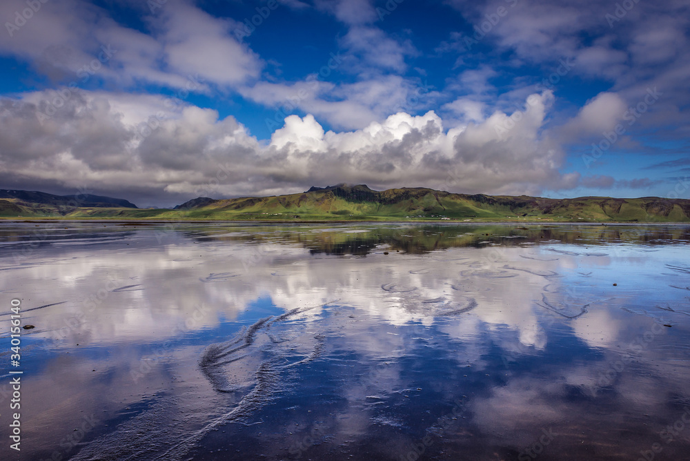 Reflection in the water of Dyrholaos estuary near cape Dyrholaey in Iceland