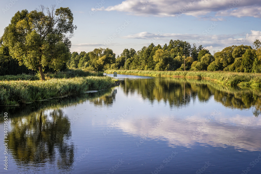 Clouds reflecting in the Biebrza River, view from Debowo Lock near Debowo village, Poland