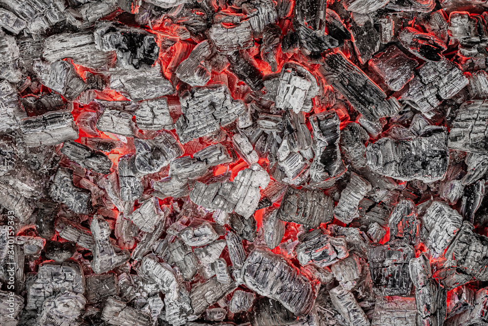 Hot white and black coals smolder in the grill Hot white and black coals smolder in the grill