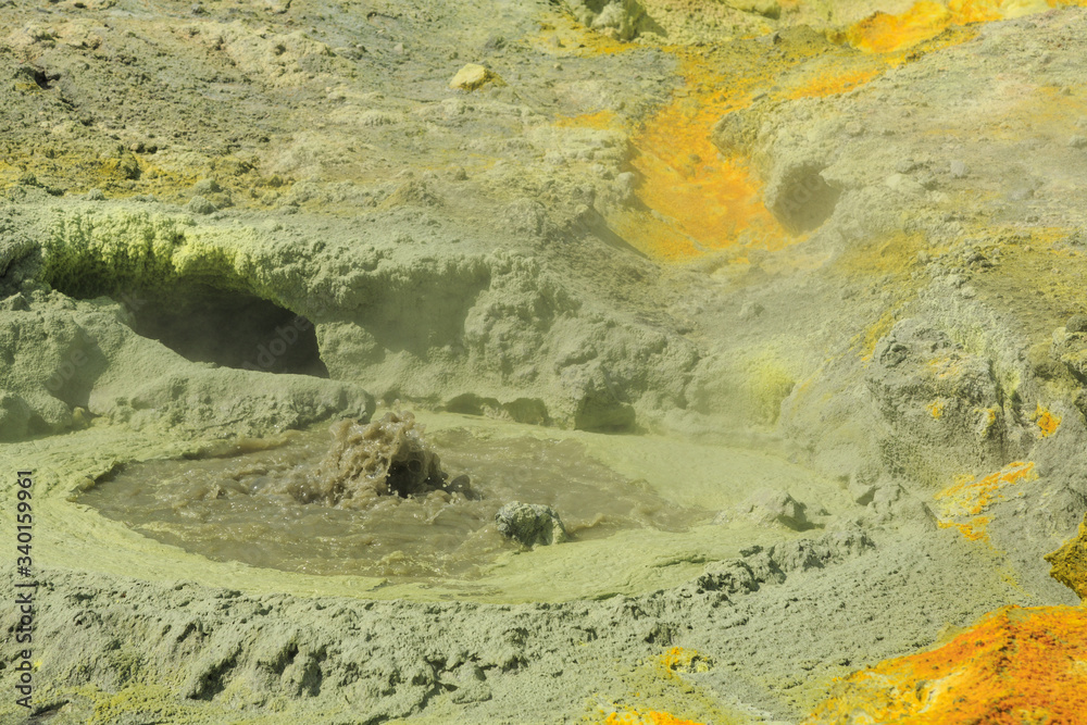 A bubbling volcanic fumarole surrounded by yellow sulfur deposits. White Island, New Zealand