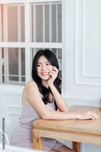 Beautiful Asian woman wear dress pants pink. Sitting on chair and white background.