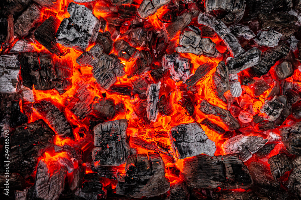 Hot white and black coals smolder in the grill