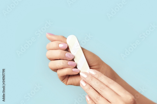 Close up photo of woman doing manicure with nail file. Fototapeta