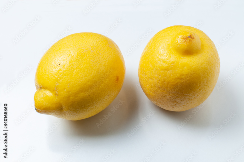 two yellow lemons lying on white background two yellow lemons lying on white background