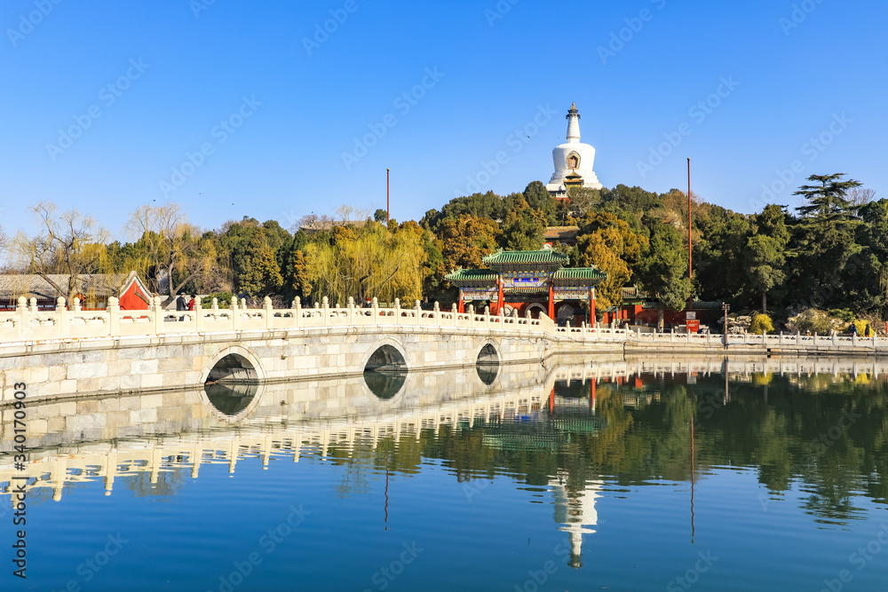 The white tower in Beihai Park, Beijing, China. Stone bridge and lake water in Beihai Park.