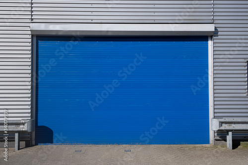 Roller shutter door and concrete floor outside factory building for industrial background.