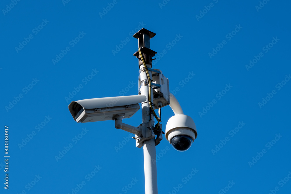 Security camera's outside with blue sky backdrop Security camera's outside with blue sky backdrop