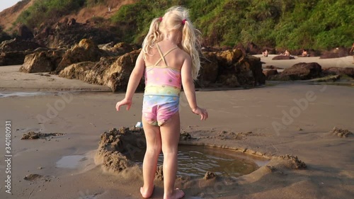 A child plays on the sea sandy beach, slow motion. Concept of a happy childhood