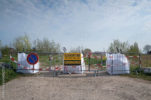 Concept of coronavirus quarantine. Coronavirus written on stop sign on the control barrier at the entrance to a infectious place. blocked roadway, control