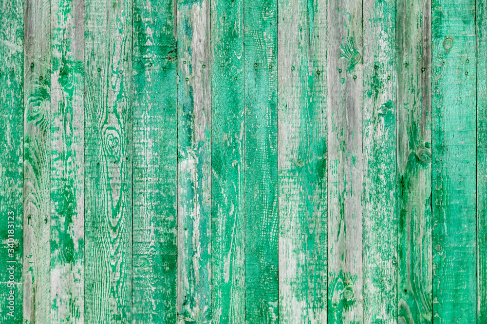 Wooden boards on an old green fence as an abstract background.