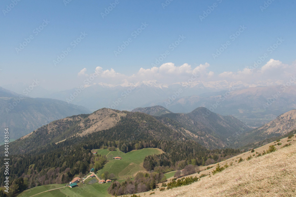 Rural contryside in mountains. Agricultural fields on hills with mountains on background.