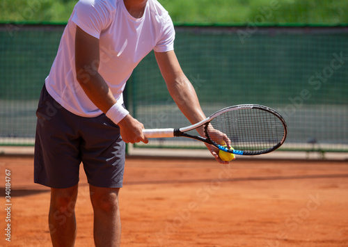 A man plays tennis on the court in the park. © schankz