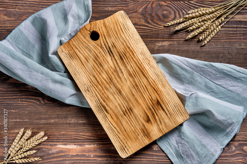 Overhead view of wooden cutting board with napkin on a table