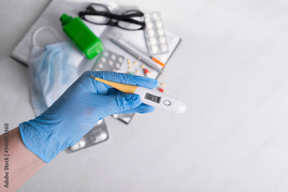 medicines along with a thermometer are on the table, flat lay. vitamins, nutritional supplements, insulin syringe, doctor's glasses. thermometer with high temperature. medical mask with an antiseptic medicines along with a thermometer are on the table, flat lay. vitamins, nutritional supplements, insulin syringe, doctor's glasses. thermometer with high temperature. medical mask with an antiseptic