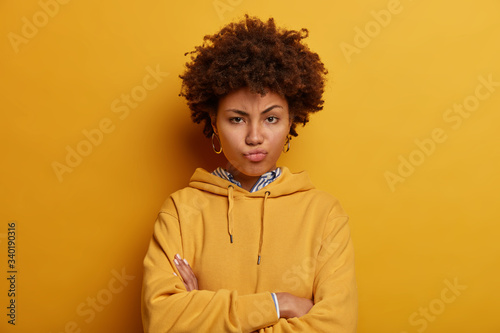 Tela Skeptic angry ethnic woman expresses suspision, stands with arms folded, pouts l