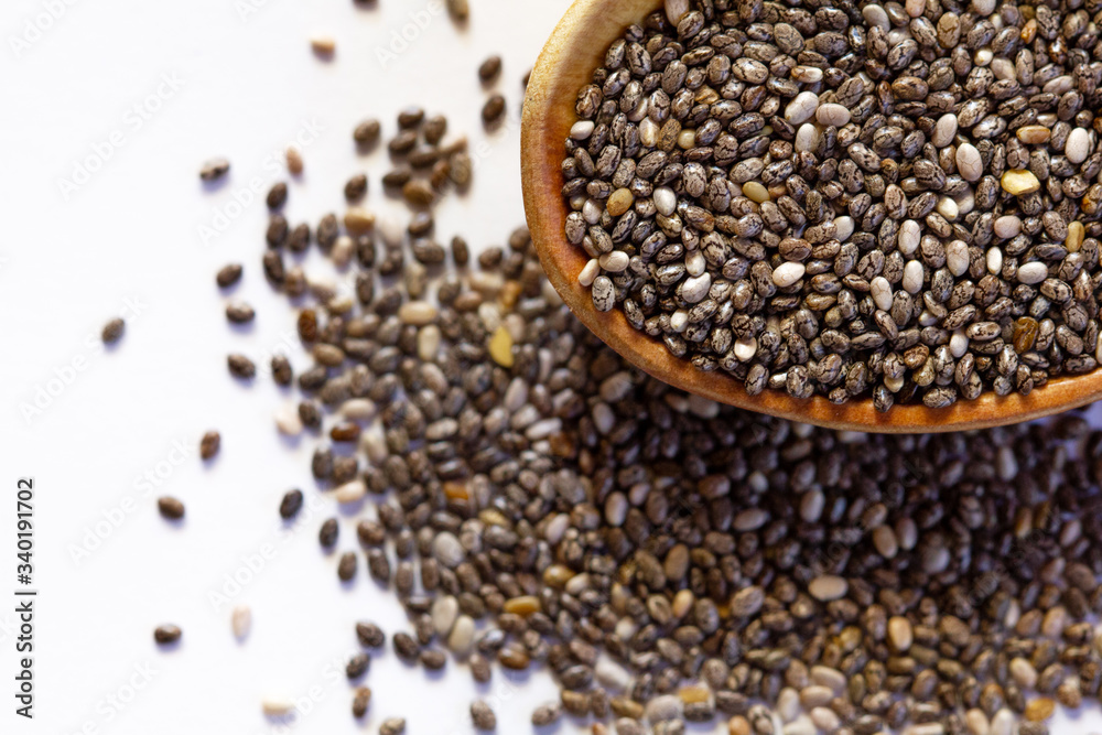 Black Chia seeds in a wooden spoon close-up. Macrophotography of Chia. Health food. Good nutrition. Nutritional Supplement.Top view. Black Chia seeds in a wooden spoon close-up. Macrophotography of Chia. Health food. Good nutrition. Nutritional Supplement.Top view.