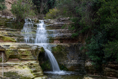 Beautiful waterfall splashing in the canyon creating a small lake