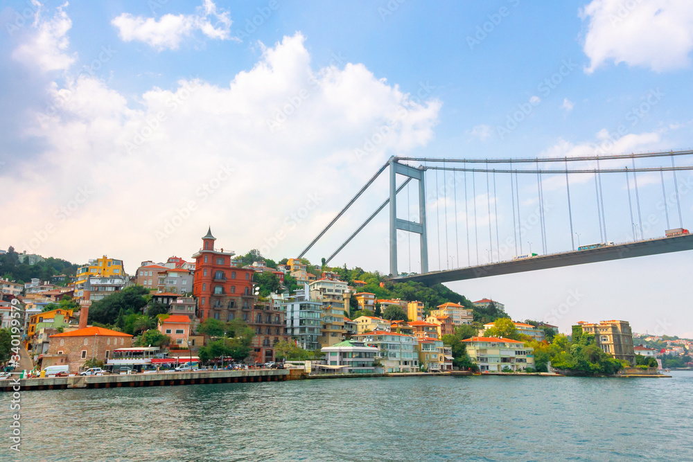 Fototapeta premium istanbul, turkey - AUG 18, 2015: fatih sultan mehmet bridge above the bosphorus. beautiful cityscape of historical area observed from the water on a sunny summer day. calm weather with fluffy clouds
