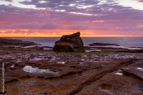 Coastal sunrise skies on a rocky Sydney reef at low tide