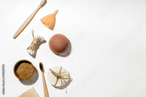 Zero waste bathroom accessories, natural eco bamboo toothbrushes, coconut soap, konjac sponge, clay mask, menstrual cup, reusable cotton sponges and bamboo ear sticks. Plastic free beauty essentials. © Anastasia Gubinskaya