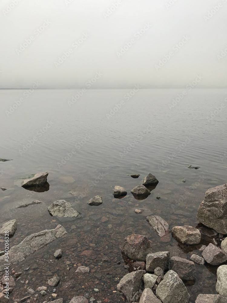Obraz premium Calm waves at the Gulf of Finland at overcast foggy day