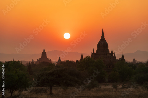 Sunset over ancient temples, pagodas and stupas in Old Bagan, Myanmar Peaceful Asian landscape with Buddhist temple silhouettes. Sacred, serene sky and beautiful scenery.