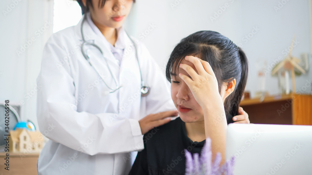 Fototapeta premium Young patient serious headache sitting on table, Asian female doctor talking for comforting for peace of mind, Medicine student treatment in hospital hopefully for cheering trust treatment