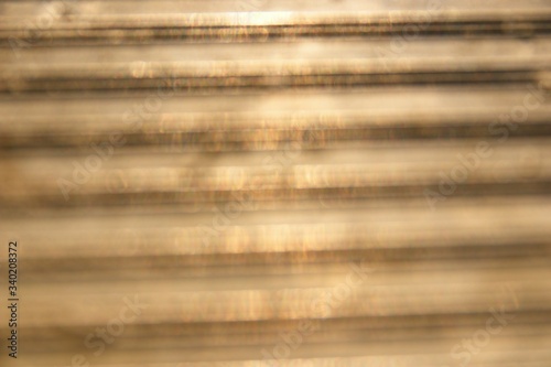 Blurred steel plate has golden reflections on the surface, Light dark gold concept for background.