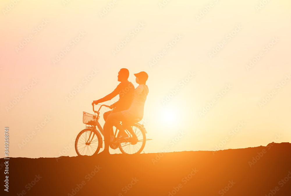 Fototapeta premium silhouette of couple driving bike happy time sunset