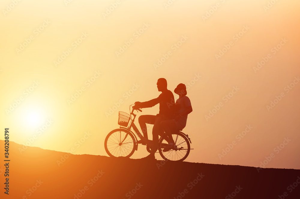 Fototapeta premium silhouette of couple driving bike happy time sunset