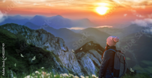 a girl with backpack in the top of the mountain at morning sunrise. © Njay