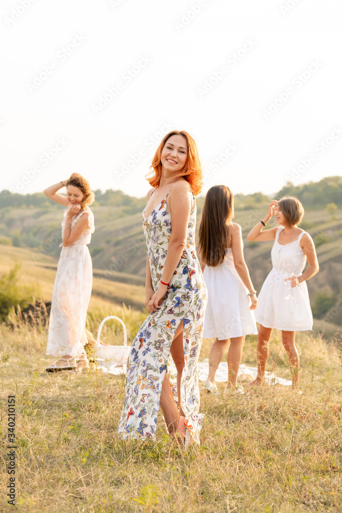 The company of happy female friends having fun and dancing outside in a picnic at hills. The company of happy female friends having fun and dancing outside in a picnic at hills.