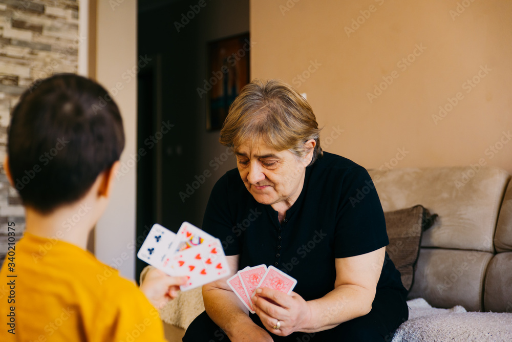 Φωτογραφία Active little preschool kid boy and grand grandmother playing card game together