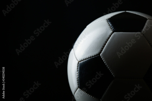 classic soccer ball with shadow on black background with copy space