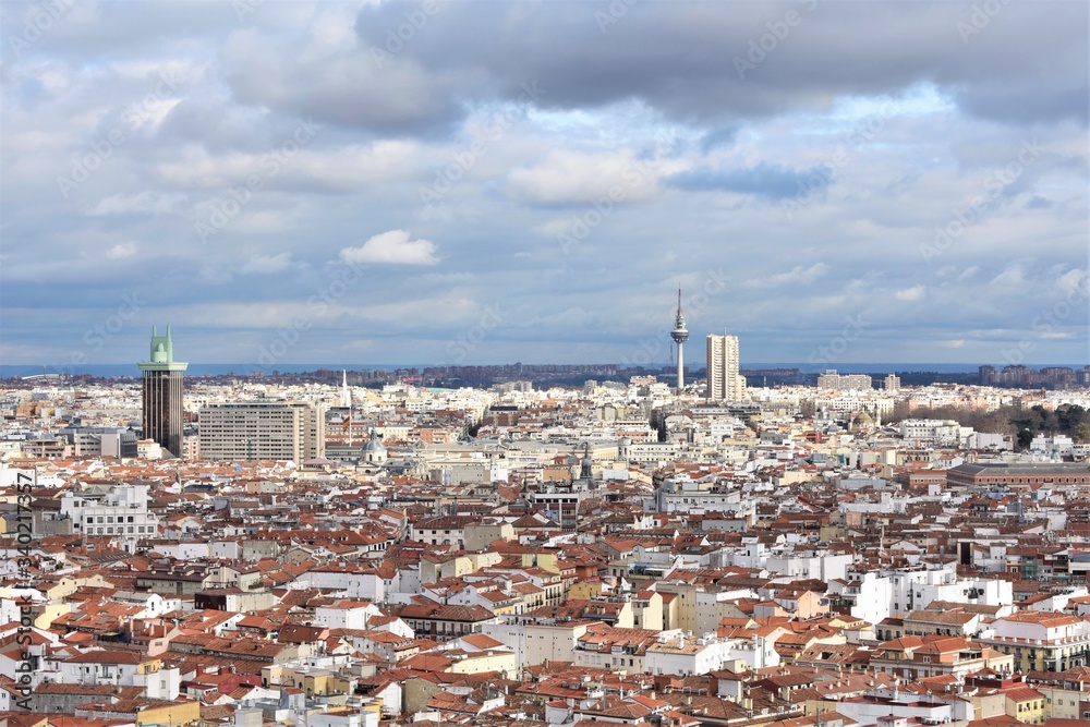 Aerial panorama of the Madrid (Spain) skyline on a cloudy day with the roofs and domes of the old part of the city in the foreground and Columbus tower and 