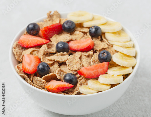 Multigrain wholegrain healthy cereal with banana and fresh berries strawberries and blueberries for Breakfast. Concept of delicious and healthy food.
