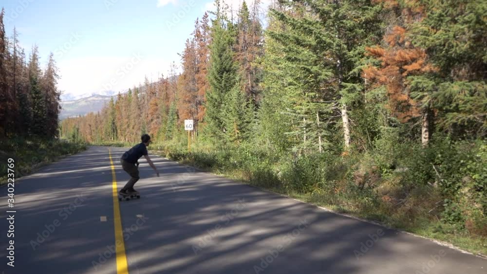 Man skating down a beautiful mountain empty road. Man skating down a beautiful mountain empty road.