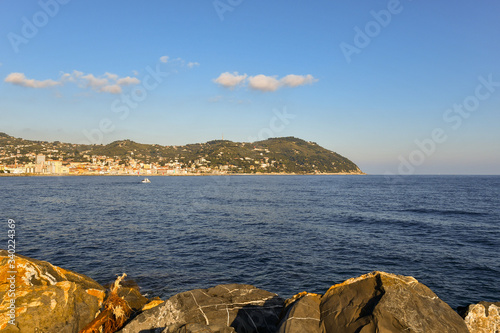 Seascape from the rocks with the coastline and Capo Berta cape in the background in a sunny day, Imperia, Liguria, Italy photo