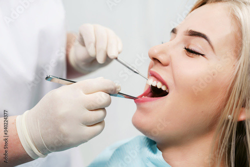 Dentist examining a patient's teeth in modern dentistry office. Closeup cropped picture with copyspace