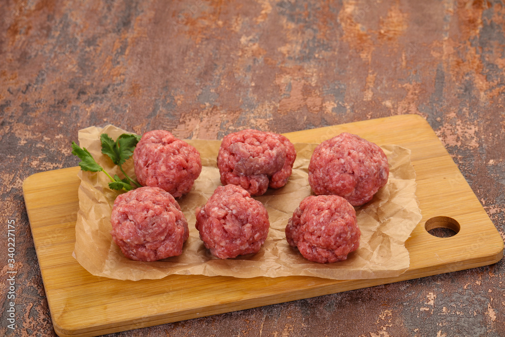 Raw meatball over wooden background Raw meatball over wooden background