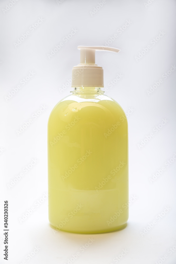 plastic bottle of yellow antiseptic soap with dispenser on a white background plastic bottle of yellow antiseptic soap with dispenser on a white background