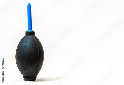 A camera dust blower isolated against a white background with room for copy text to the right