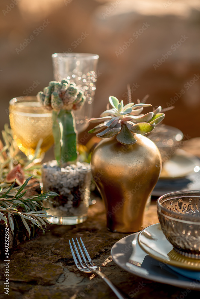 Wedding table setting in rustic style in nature, decoration of glassware, fresh flowers and eucalyptus branches